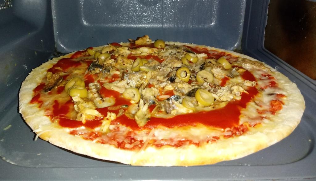 Pizza de Mercadona cocinada en el microondas. mejorada con más queso, tomate, aceitunas y caballas estofadas.
